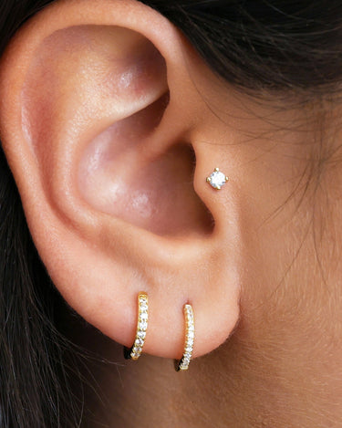 1.5mm diamond push pin earrings as tragus earrings on model.