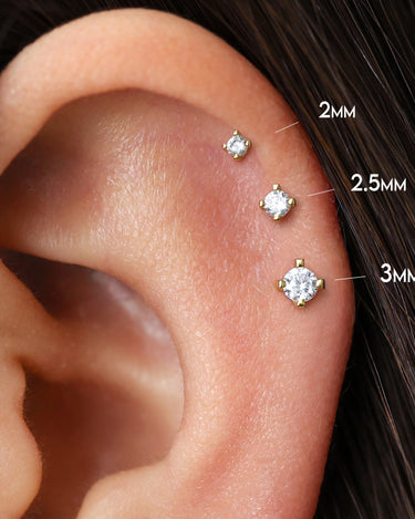 Diamond push pin earrings in 18K gold and sterling silver as helix earrings on model. 