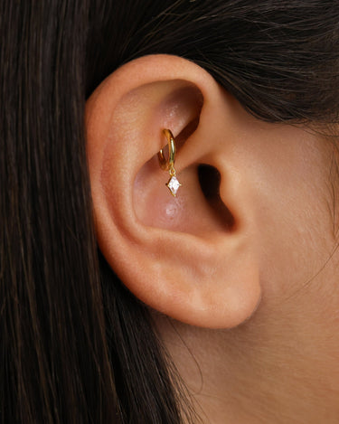 Diamond mini charlotte hoop earrings in 18k gold as rook earrings on model.