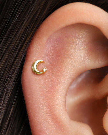 Moon & stone flat back earrings in 18K gold as helix earrings on model.