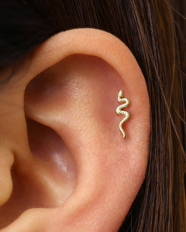 serpent flat back earrings in 18k gold as helix earrings on model