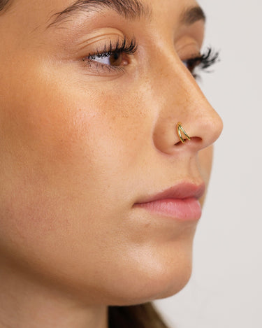 Solid double clicker hoop earrings in 18K gold as cartilage earrings on model. 